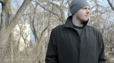 Handsome man smokes at a park Vidéo 59857012