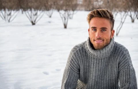 Handsome man in snow posing for camera Stock Photos