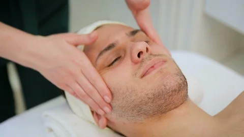 Handsome man in spa relaxing receiving face massage Stock Footage 111830633