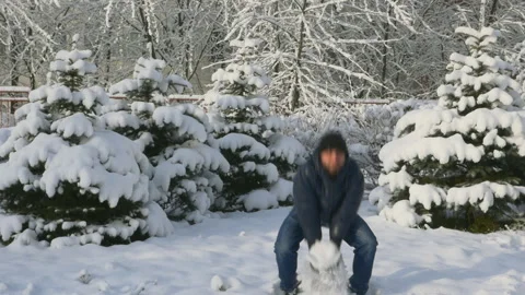 Handsome man standing and throwing snow in the sky in winter day slow motion Stock-Footage 96356017