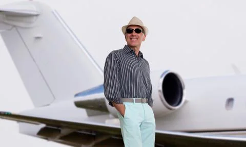 Handsome man standing next to a private jet Stock Photos
