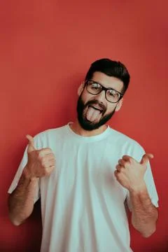Handsome man standing on red background who is happy and showing big like Stock Photos