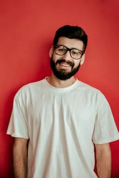 Handsome man standing on red background who is happy Stock Photos