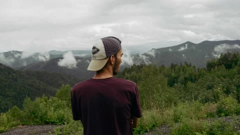 Handsome man stands on the top of the mountain Stock Footage 169660282