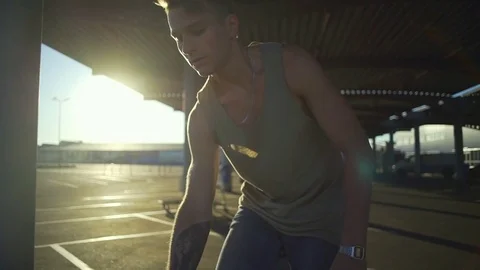 Handsome man stay on the empty parking and touch hair sundown slow motion rapid Stock Footage 78040775