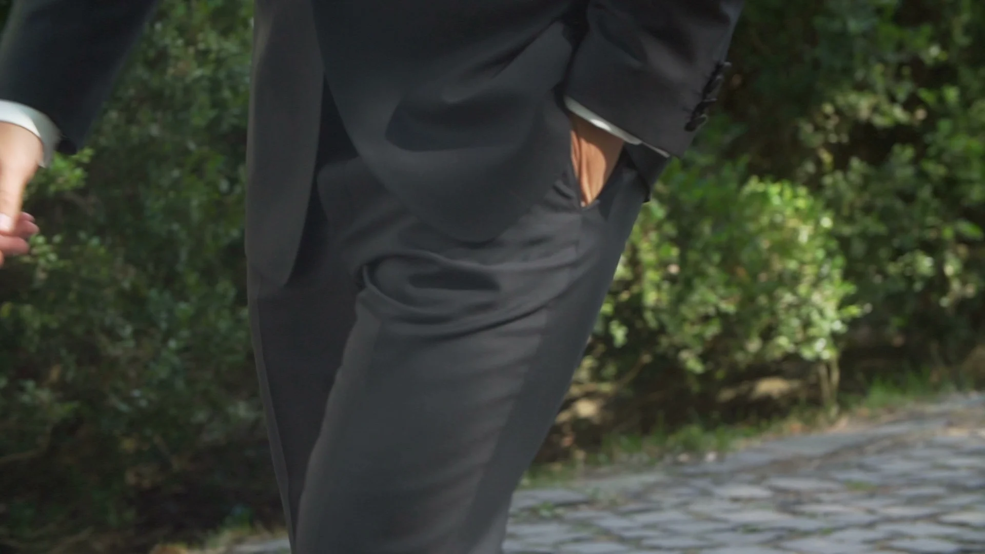 The handsome man in stylish black suit is keeping his hand in pocket while