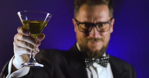 Handsome man in suit drinking champagne on black background Stock Footage 130817063
