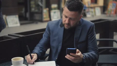 Handsome Man in Suit is smiling Charmingly while browsing Internet on his Phone. Stock Footage 172504715