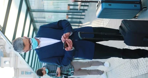 Handsome man with suit using phone while awaiting for departure for his trip Stock Footage 244251636