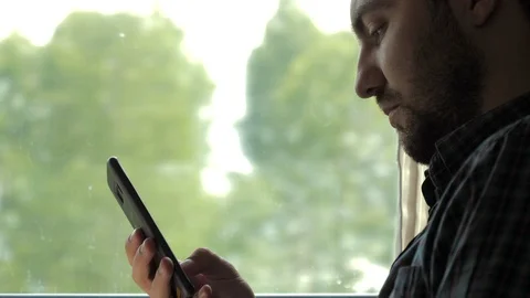 Handsome man surfing in web with his smartphone in a train. Stock-Footage 112954594