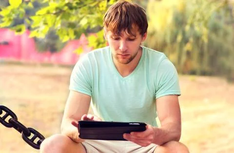 Handsome man with tablet pc in the park outdoor young businessman technology  Stock Photos