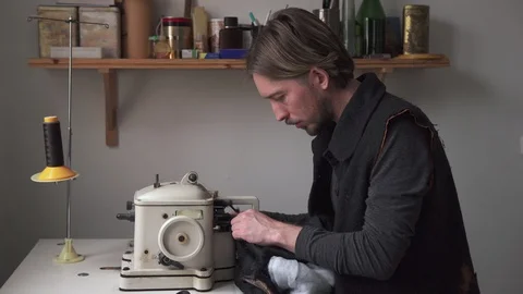 Handsome man tailor working on furrier machine in workshop Stock Footage 100617670
