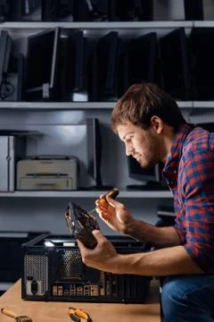 Handsome man taking the old computer equipmnet apart Stock Photos