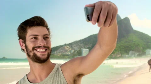 Handsome man taking a selfie on smartphone at Ipanema beach Stock Footage 59376604