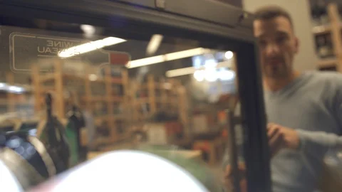 Handsome man is taking white wine bottle from the fridge Wine bottles are laying Stock Footage 99386751