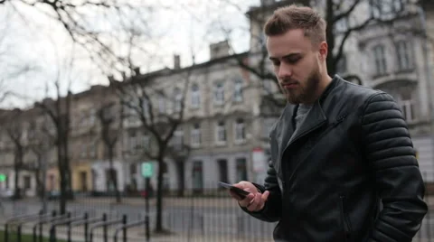 Handsome man talking on his phone in the street Stock Footage 63468172