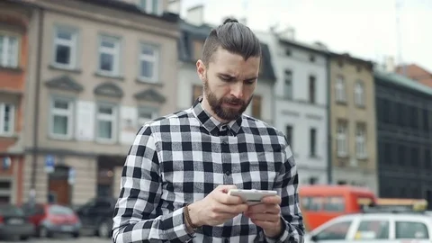 Handsome man texting messages on smartphone and doing serious look to the camera Video stock 73408767