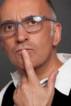 Handsome man thinking with his hand at the lip Stock Photos