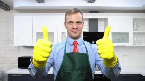 Handsome man in tie and apron wearing rubber gloves Stock Illustration