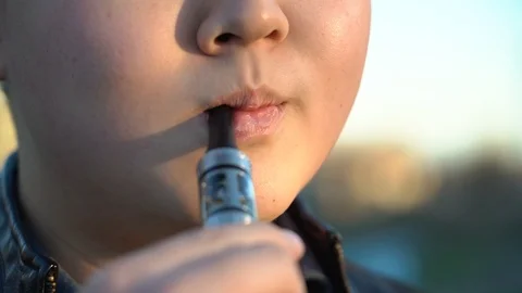 Handsome man in town with an e-cigarette makes a puff Stock Footage 99872812