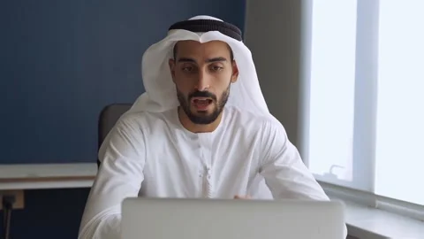 Handsome man with traditional clothes working in an office of Dubai Stock Footage 167856864