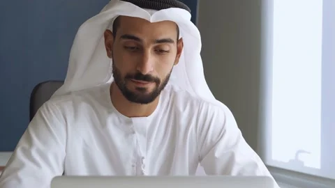 Handsome man with traditional clothes working in an office of Dubai Stock Footage 167857249