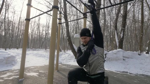 Handsome man training workout exercises with expander on sports ground Video stock 87892448