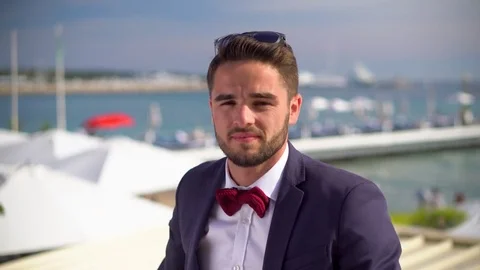 Handsome man in a tuxedo taking out sunglasses Stock Footage 78366783