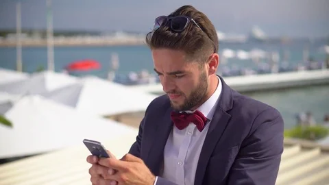 Handsome man in a tuxedo texting Stock Footage 78366611