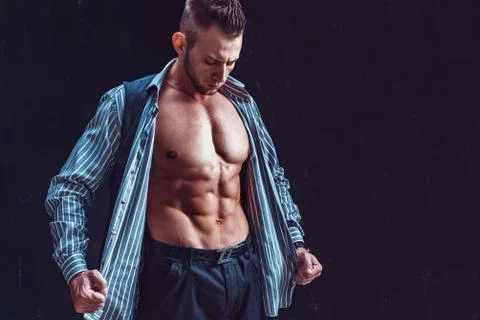 Handsome man undressing Stock Photos