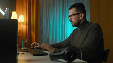 Handsome man uses computer home. programmer looks at monitor screen. freelance Stock Footage 170359952