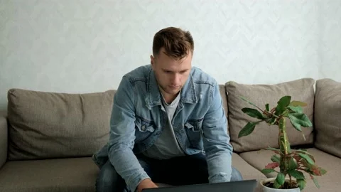 A handsome man uses a laptop. Work at home. Freelance. Distant work. Stock Footage 141199162