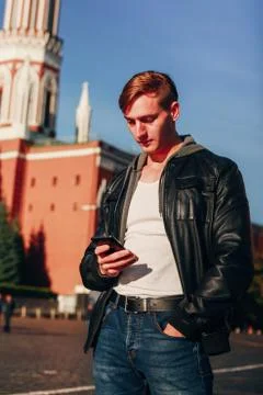 Handsome man uses the phone while standing against the background of the Kremlin Stock Photos