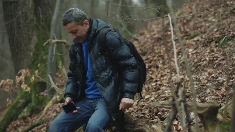 Handsome man uses smarphone in the spring forest smile feel happy technology Stock Footage 127168459