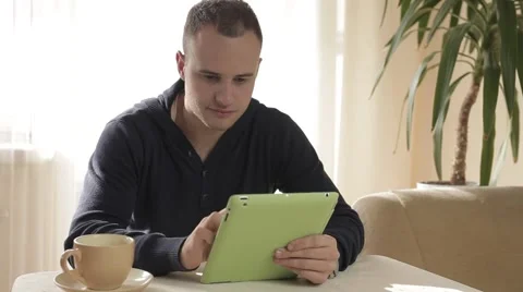 Handsome man using his tablet pc relaxing on chair Stock-Footage 43219411