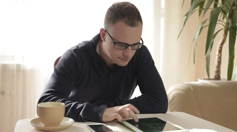 Handsome man using his tablet pc and mobile phone Stock Footage 43219430