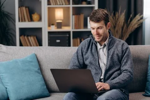 Handsome man using laptop during free time at home 스톡 사진
