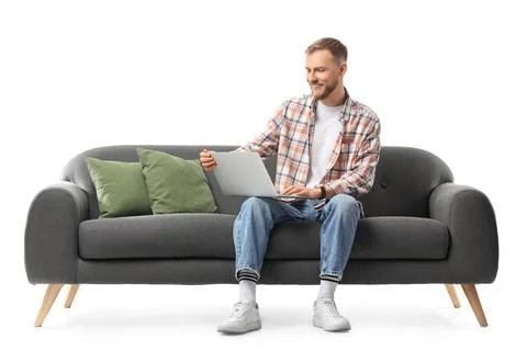 Handsome man using laptop on sofa against white background Stock Photos