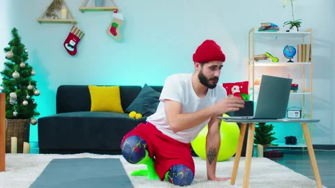 Handsome man using the laptop while sitting down on the floor in the living room Stock Footage 160808182