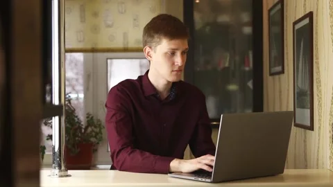 Handsome man is using a laptop, working hard in home. Work from home Stock Footage 148043226