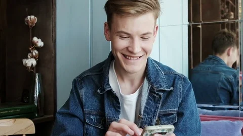 Handsome man using mobile phone in cafe. Male student using smartphone in cafe Stock Footage 81138005