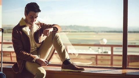 Handsome man using smartphone in airport Stock Footage 86469766