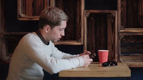 Handsome man using smartphone at the cafe Stock Footage 75650682
