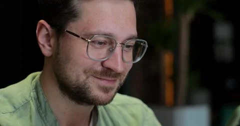 Handsome man using smartphone in Cafe. Male in glases smiling, checking socia 写真素材