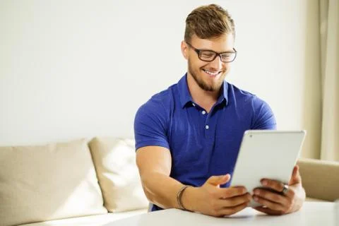 Handsome man using tablet pc at home Stock Photos