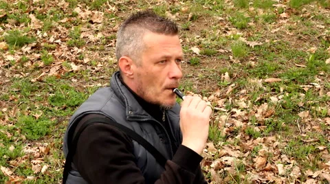 Handsome man vaping e cigarette outdoor in the field Stock Footage 48968782