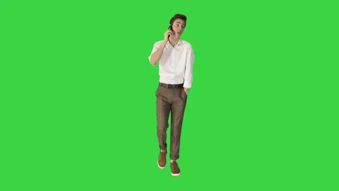 Handsome man is walking and talking on the phone on a Green Screen, Chroma Key. Stock-Footage 143704778