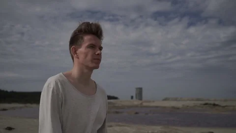 Handsome man walking on beach Stock Footage 80707893