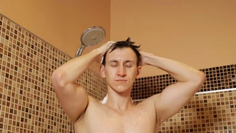 Handsome man washes his head in the shower Stock Footage 130896454