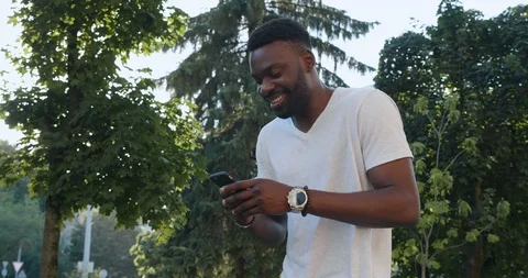 Handsome man wearing basic White T-shirt walking in the Town, working on his Stock Footage 121915838